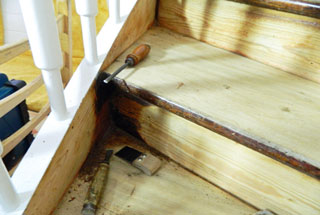 Das Bild zeigt die handwerkliche Reparatur einer Treppe. Es sind verschiedene Werkzeuge zu sehen. Stechbeitel und Ziehklingen. Die alte Farbe der Treppe ist bereits entfernt. Der Link fuehrt zur Seite Treppenrenovierung.